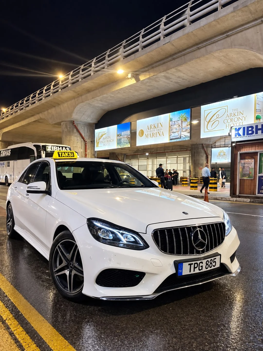 Havalimanı önünde gece taksi ve transfer için kullanılan beyaz araç